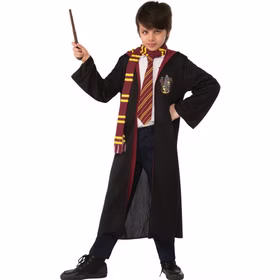 Junge trägt schwarzes Harry Potter Gryffindor Kostüm mit Umhang, rot-goldenem Schal, Krawatte und braunem Zauberstab.