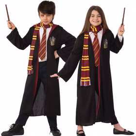 Junge und Mädchen zeigen das Harry Potter Gryffindor Kinderkostüm mit schwarzem Umhang, Schal, Krawatte und Zauberstab.