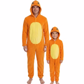 Erwachsener und Kind tragen gemeinsam orangefarbene Pokémon Glumanda Plüsch-Overalls mit gelbem Bauchbereich und Kapuze.