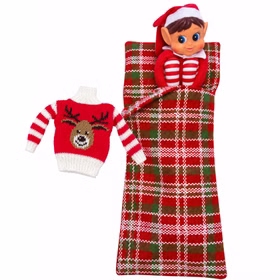 Wichtelmädchen und Rentierpullover als Set Weihnachtswichtelmädchen in roter Kleidung liegt in einem karierten Schlafsack. Daneben ist der rote Mini-Pullover mit Rentiermotiv als zusätzliches Kleidungsstück abgebildet.