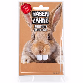 Hasenzähne weiß Kostüm Zubehör Vorderseite Weiße Hasenzähne als Kostüm-Zubehör in Originalverpackung mit Hasenmotiv, Frontansicht auf sauberem weißem Hintergrund.